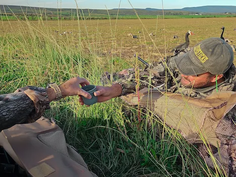 Two hunters sharing a cup of coffee in their blinds while waiting for Ducks